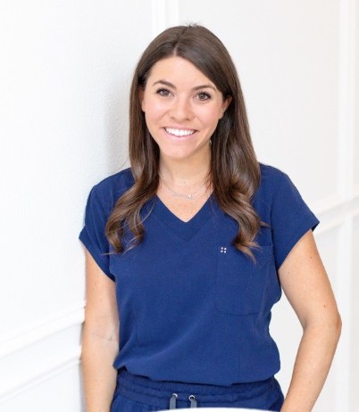 Kristen Gaffney, speech-language pathologist, smiling in navy scrubs